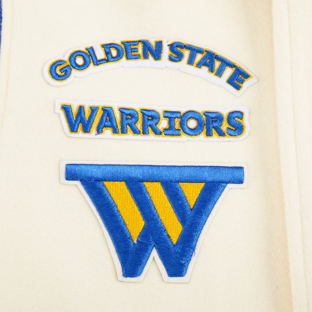 NBA GOLDEN STATE WARRIORS CLASSIC STUDIO BLOUSON COLLÉGIAL POUR GARÇON JUNIOR (COQUILLE D'ŒUF/BLEU ROYAL)