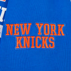 NBA NEW YORK KNICKS CITY ARCH HAUT EN MOLLETON À GLISSIÈRE AU QUART POUR HOMME (BLEU ROYAL)